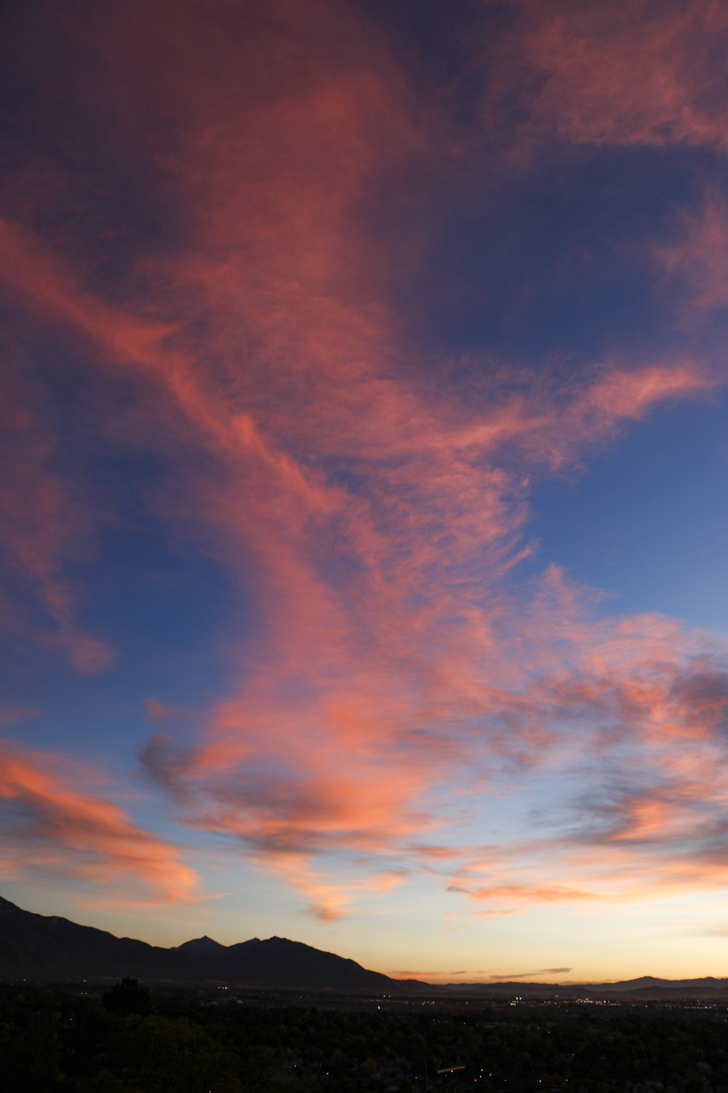 pink clouds flare up above the town and mountains